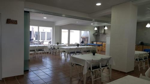 CAN CALLAU في بوبل نو ديل دلتا: غرفة طعام مع طاولات بيضاء وكراسي بيضاء