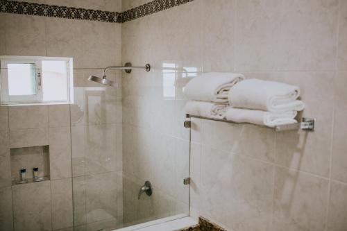 a bathroom with a glass shower with towels on top at Diamond Bay in Mazatlán