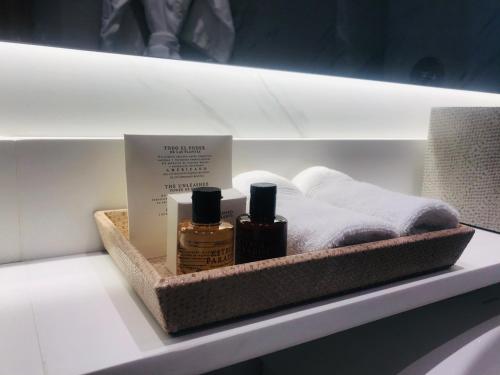 a shelf with two bottles of essential oils and towels at Cassa Luxury Homes in Bogotá