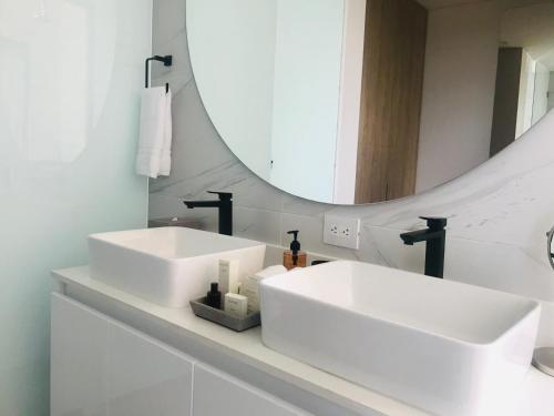 a bathroom with two white sinks and a mirror at Cassa Luxury Homes in Bogotá