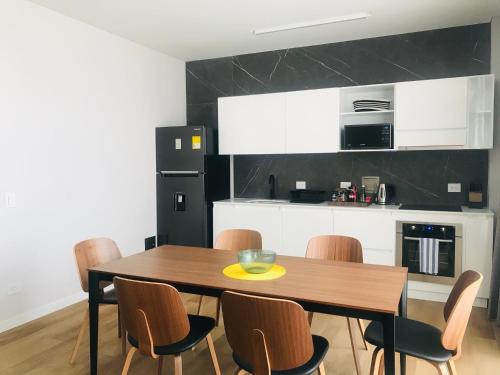 a kitchen with a wooden table and chairs at Cassa Luxury Homes in Bogotá