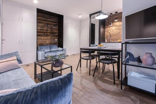 a living room with a couch and a table with chairs at City Break Gdańsk Rajska 8 Apartamenty in Gdańsk