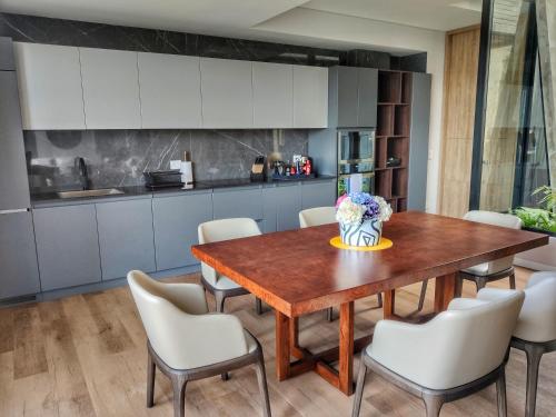a kitchen with a wooden table and white chairs at Cassa Luxury Homes in Bogotá