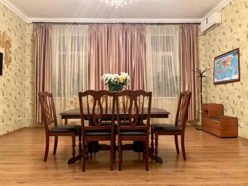 a dining room table with a vase of flowers on it at Apartment on Zhukovskogo in Odesa