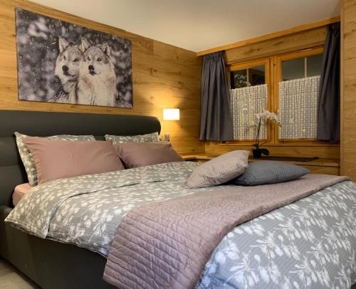 a bedroom with a bed with two dogs on the wall at Kirchplatz Apartment Lupus in Zermatt