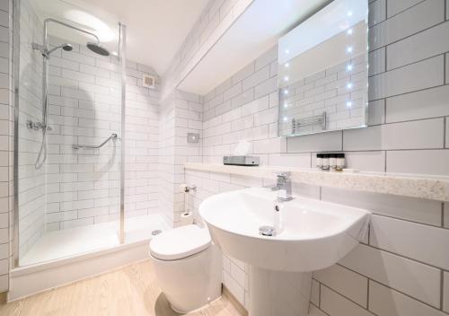 a bathroom with a sink and a toilet and a shower at The County Hotel by Innkeeper's Collection in Lytham St Annes