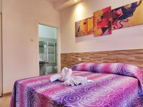 a bedroom with a pink bed with a stuffed animal on it at B&B La Magnolia in Caprino Veronese