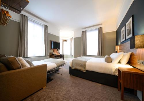 a hotel room with two beds and a couch at The County Hotel by Innkeeper's Collection in Lytham St Annes