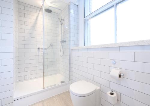 a white bathroom with a shower and a toilet at The County Hotel by Innkeeper's Collection in Lytham St Annes