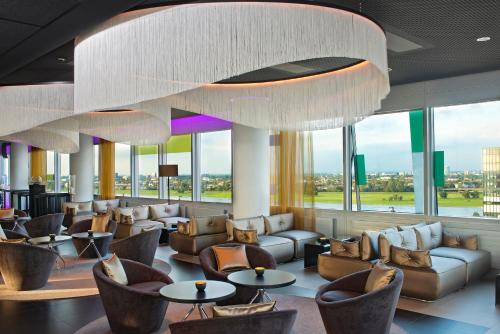 a lobby with couches and tables and a large chandelier at INNSiDE by Meliá Düsseldorf Hafen in Düsseldorf