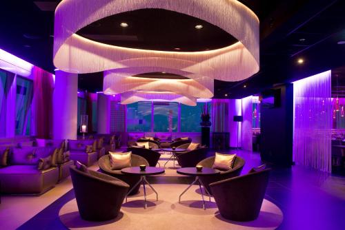 a room with purple lighting and tables and chairs at INNSiDE by Meliá Düsseldorf Hafen in Düsseldorf