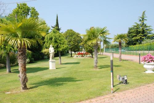 a park with a statue and palm trees at Residence La Margherita in Lazise