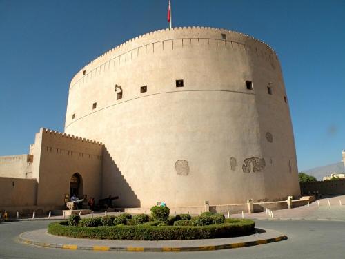 a large building with a flag on top of it at Nizwa Park House Apartment in Nizwa