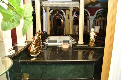 a bathroom with gold vases on a counter in a room at Sheikh Apartment in Baku in Baku