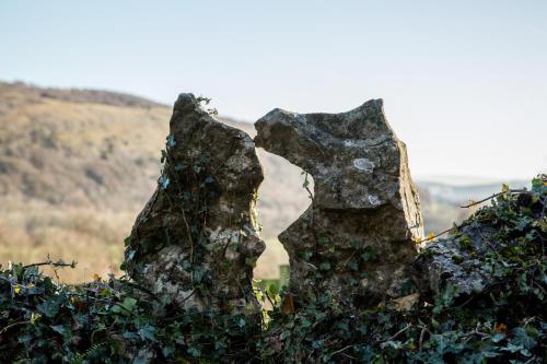 two statues of two cats sitting on a rock at Witherslack Hall Farmhouse in Grange Over Sands