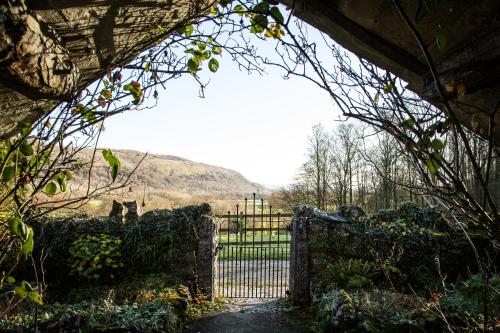 a gate in a garden with a view of a field at Witherslack Hall Farmhouse in Grange Over Sands