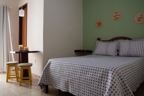 1 dormitorio con 1 cama con manta azul y blanca en Suíte 05 Apês do Peró - Até 3 pessoas - Centro, en Cabo Frío