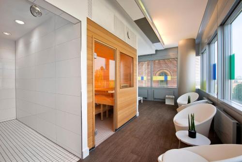 a bathroom with two toilets and a table and chairs at INNSiDE by Meliá Düsseldorf Hafen in Düsseldorf