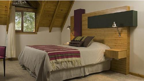 ein Schlafzimmer mit einem großen Bett in einem Zimmer in der Unterkunft Hosteria ACA al Sur in Villa La Angostura