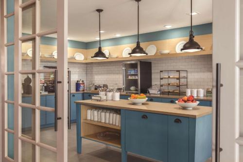 a kitchen with blue cabinets and a counter with fruits on it at Country Inn & Suites by Radisson, Lubbock Southwest, TX in Lubbock