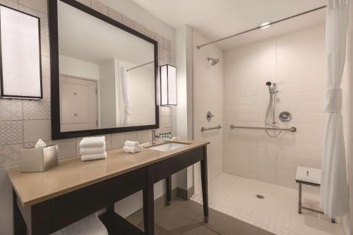 a bathroom with a sink and a mirror and a shower at Country Inn & Suites by Radisson, Lubbock Southwest, TX in Lubbock