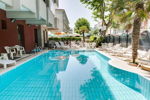 uma piscina com azulejos azuis num hotel em Hotel Giglio em Rimini