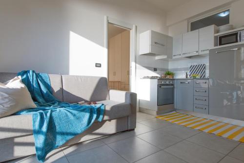 a living room with a couch and a kitchen at Babyaccommodation Family Experience in Pietra Ligure