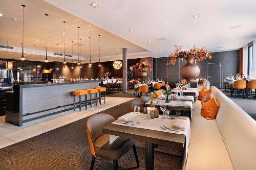 a restaurant with tables and chairs and a bar at Van der Valk Hotel Tiel in Tiel