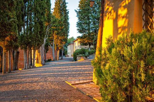 an empty street with trees and a yellow building at Villa Poggiano in Montepulciano