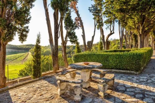 a stone patio with a table and trees at Villa Poggiano in Montepulciano