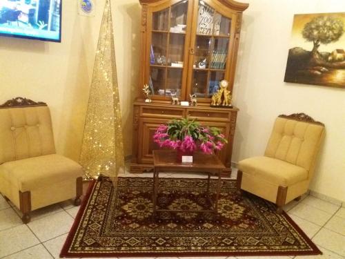a room with two chairs and a table and a christmas tree at Olympus View Rooms Sauna & Spa in Litochoro
