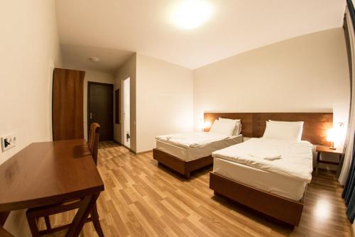 a hotel room with two beds and a desk at Hotel Deka Gudauri in Gudauri