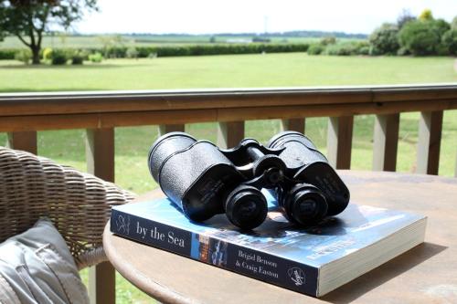 a pair of binoculars sitting on a book on a table at Luxury Escape in Hunstanton