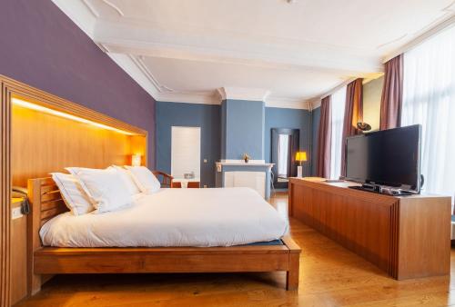 a bedroom with a bed and a flat screen tv at Hotel Hof van Aragon in Lier