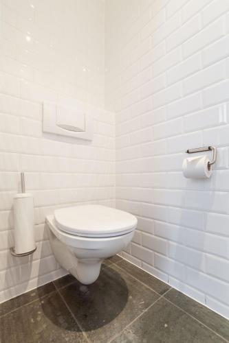 a white bathroom with a toilet in a room at Hotel Hof van Aragon in Lier