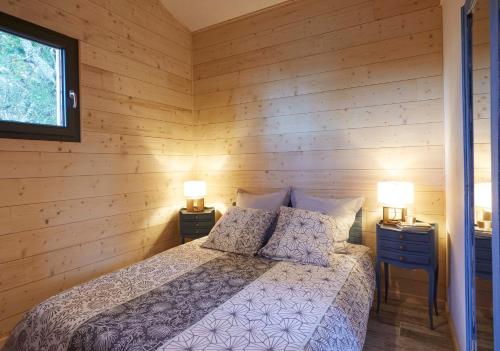 - une chambre avec un lit dans un mur en bois dans l'établissement Au courtil des chênes marins, meublé 3 étoiles, à Digosville