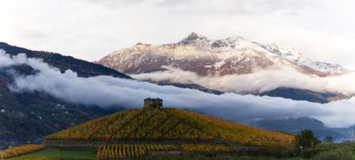 a mountain with a house on top of a hill at La Grange in Aymavilles