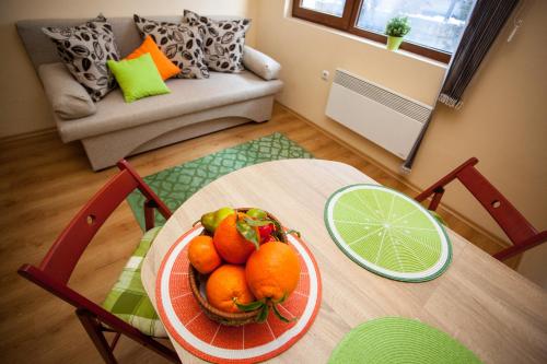 a bowl of oranges on a table in a living room at Green Orange Apartment in Bansko