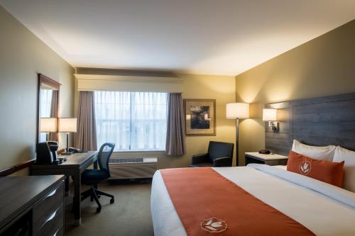 a hotel room with a bed and a desk and a computer at Amsterdam Inn & Suites Moncton in Moncton