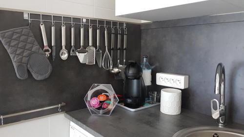 una encimera de cocina con utensilios colgados en la pared en Saint-Florent, Agréable Studio Climatisé, Vue Panoramique Sur Le Golfe en Saint-Florent