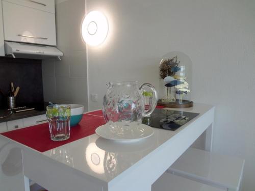 una encimera de cocina con jarrón y gafas. en Saint-Florent, Agréable Studio Climatisé, Vue Panoramique Sur Le Golfe en Saint-Florent