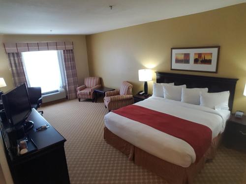 a hotel room with a large bed and a television at Country Inn & Suites by Radisson, Conway, AR in Conway
