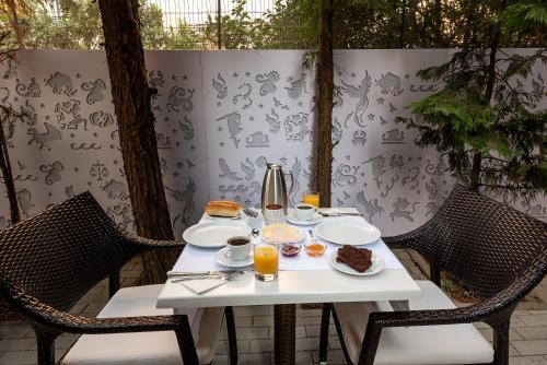 een witte tafel met eten en drinken erop bij Hotel Galaxias in Rhodos-stad