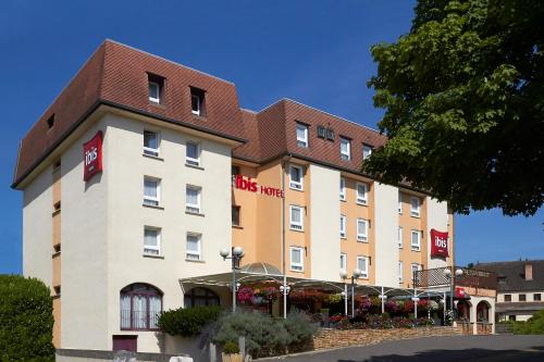 a hotel with a brown and white building at ibis Beaune Centre in Beaune