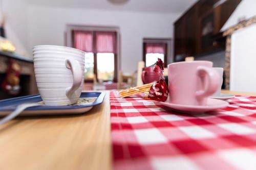 two cups on a table with a red and white checkered table cloth at La casa di Benvenuto in Montecchio