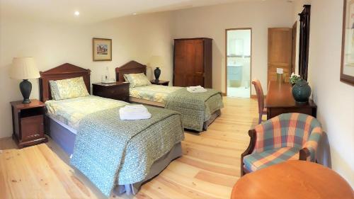 una habitación de hotel con 2 camas y una silla en La Sentinelle en Siran