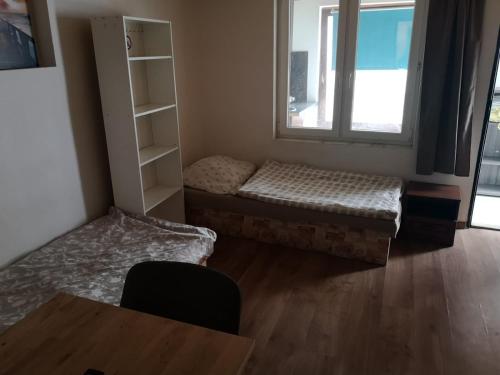 a room with two beds and a table and a window at A flat 3 in Bratislava