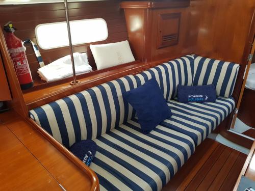a striped couch on a boat with two pillows on it at Centro Ibiza Catamaranes y Velero in Ibiza Town