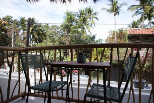 a table and chairs on a balcony with palm trees at PAL.MAR Hotel Tropical in San Francisco