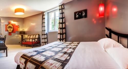 a bedroom with a bed and a chair and a window at Château de la Falque, The Originals Relais in Saint-Geniez-dʼOlt